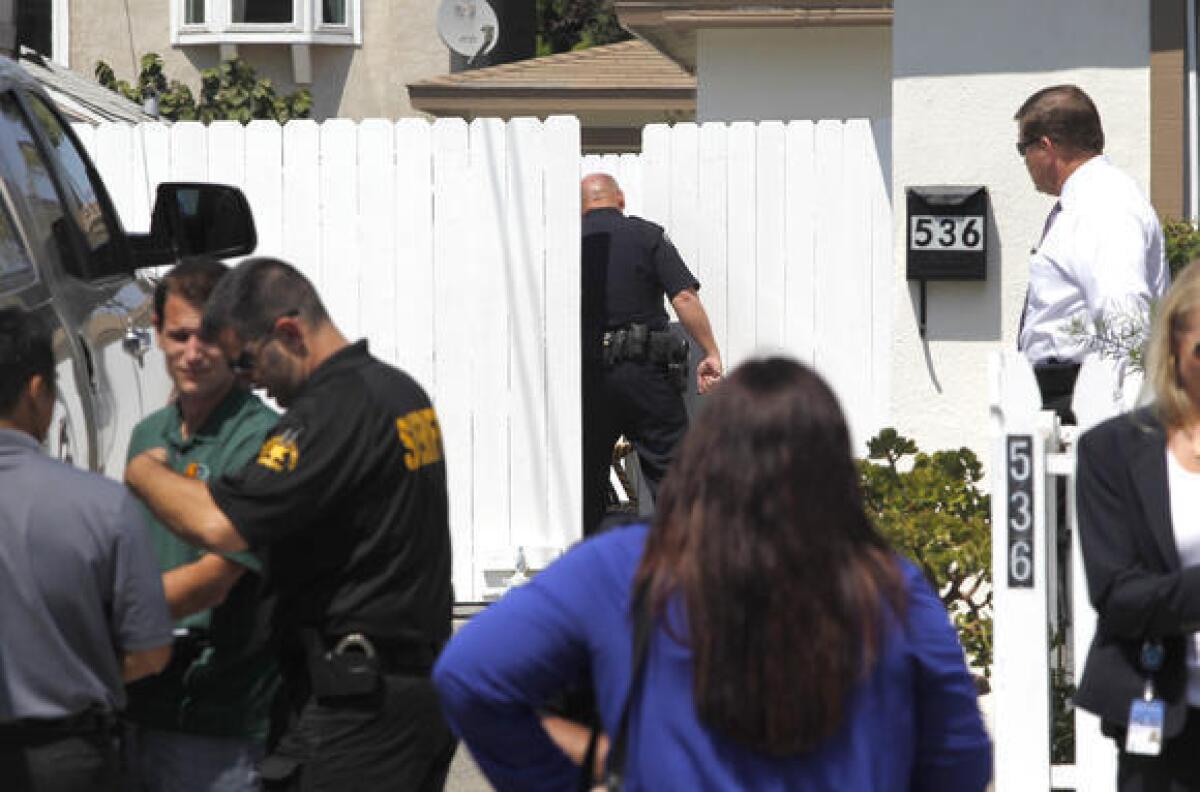 Costa Mesa police and other investigators investigate the scene where the body of John Gerard Kubat, 54, was found outside a vacant property at 536 Hamilton St.