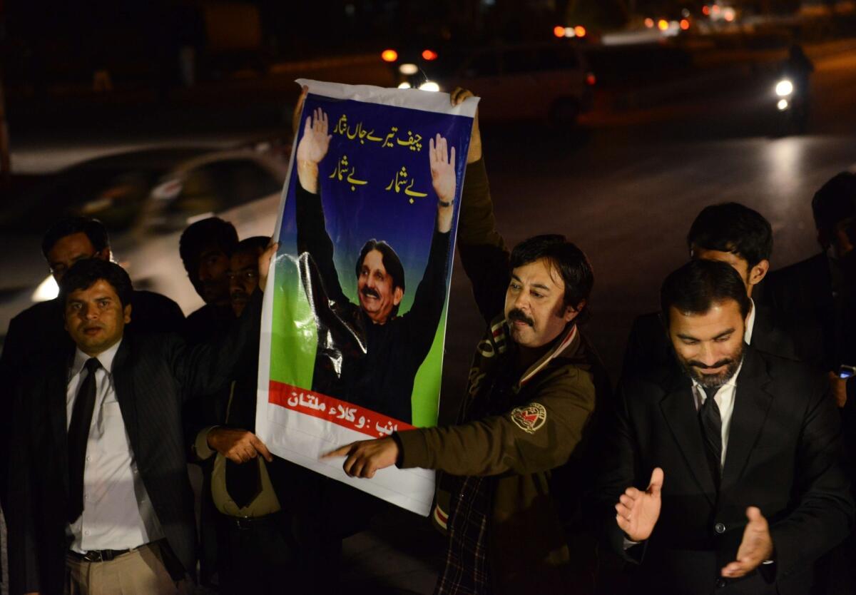 Pakistani lawyers hold up a poster of Supreme Court Chief Justice Iftikhar Mohammed Chaudhry on Wednesday as they mark his retirement outside the Supreme Court building in Islamabad.