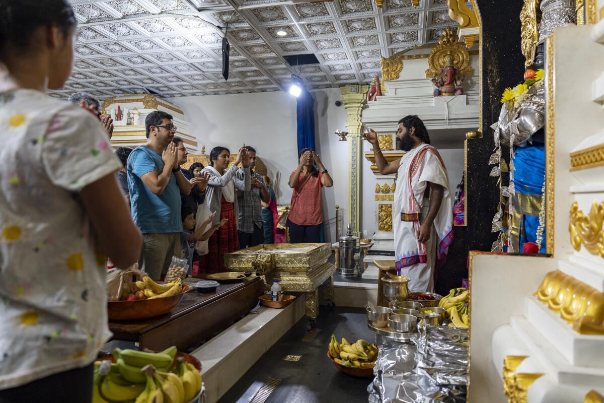 Un grupo de fieles reza a la deidad Hanuman en Sir Hanuman Mandir, 