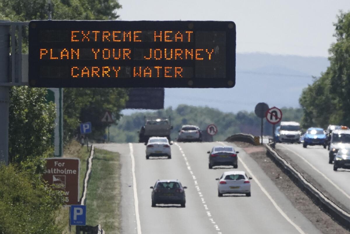 A matrix sign over the A19 road towards Teesside displays an extreme weather advisory as the UK braces for the upcoming heatwave, in England, Saturday July 16, 2022. (Owen Humphreys/PA via AP)