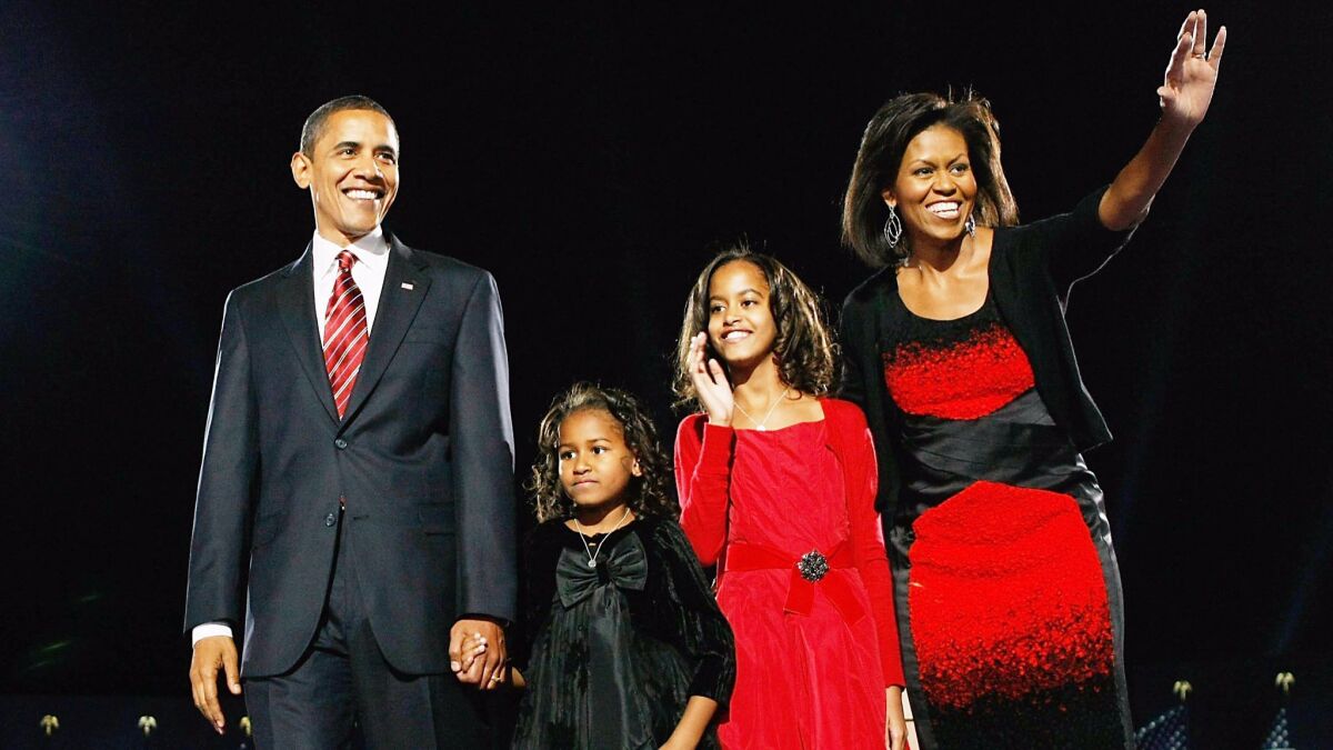 President-elect Barack Obama, Sasha, Malia and Michelle Obama during an election night gathering in Grant Park on Nov. 4, 2008 in Chicago. For the occasion, the first lady chose a red-and-black firecracker of a dress by Narciso Rodriguez.