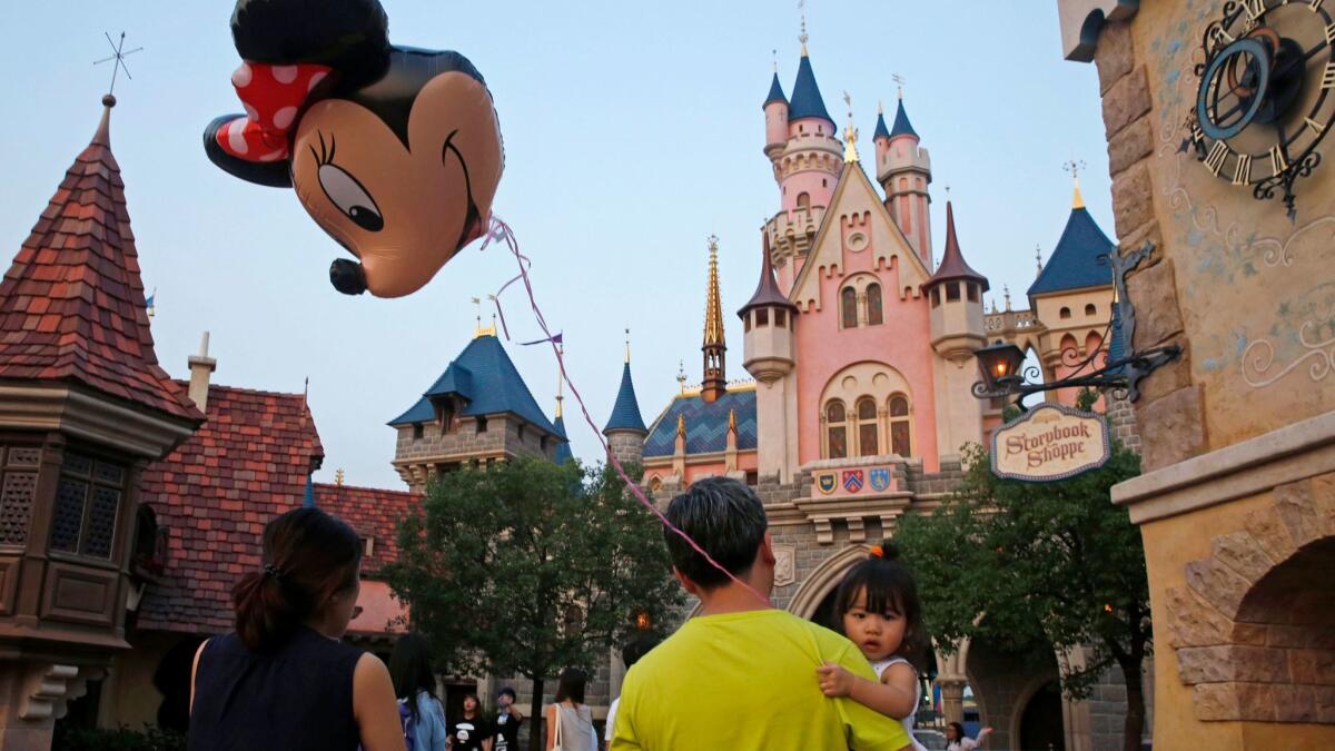 A girl holds a balloon featuring Minnie Mouse at Hong Kong Disneyland. The theme park posted wider annual losses as attendance by mainland Chinese tourists dropped amid a softer tourism market.