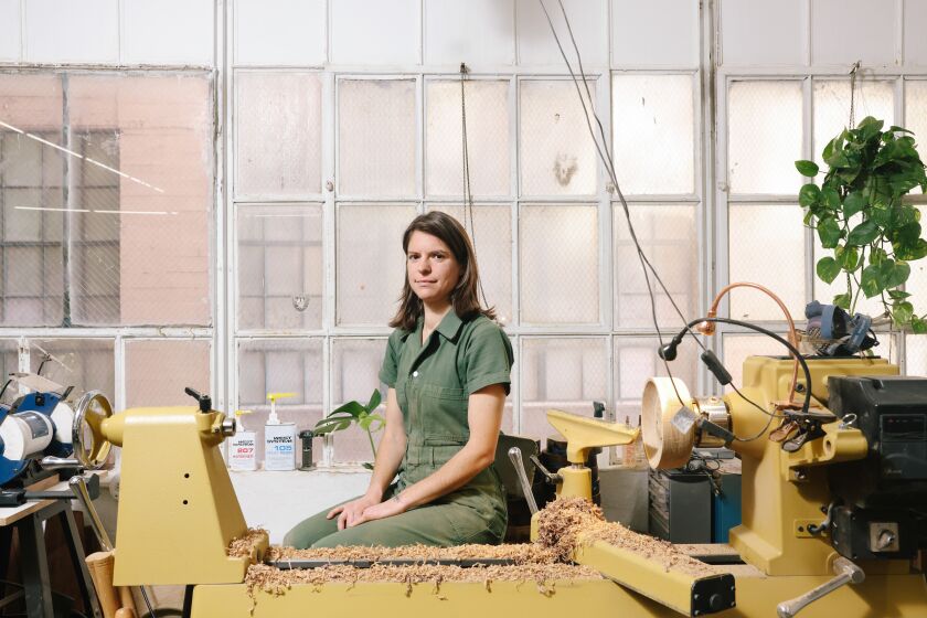 Los Angeles, CA - April 05: Woodworker Julie Jackson of Surcle Wood poses for a portrait in her studio on Wednesday, April 5, 2023 in Los Angeles, CA. She creates lamps and vases from reclaimed wood and fallen trees using a lathe in a process known as woodturning. (Dania Maxwell / Los Angeles Times)