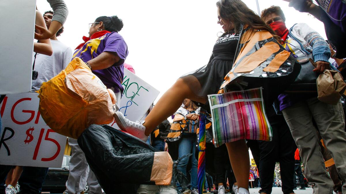 A woman steps on a piñata version of presidential candidate Donald Trump as she and a group of anti-Trump protesters march through downtown San Diego on May 27.