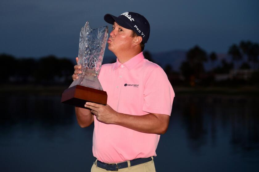 Jason Dufner poses with the trophy after winning the CareerBuilder Challenge at the TPC Stadium course in La Quinta, Calif.