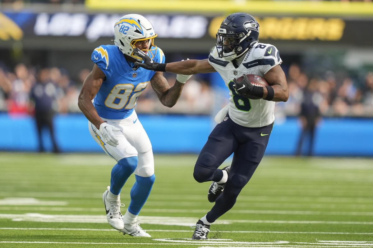 Seahawks cornerback Coby Bryant brushes off Chargers receiver Brenden Rice while returning an interception.