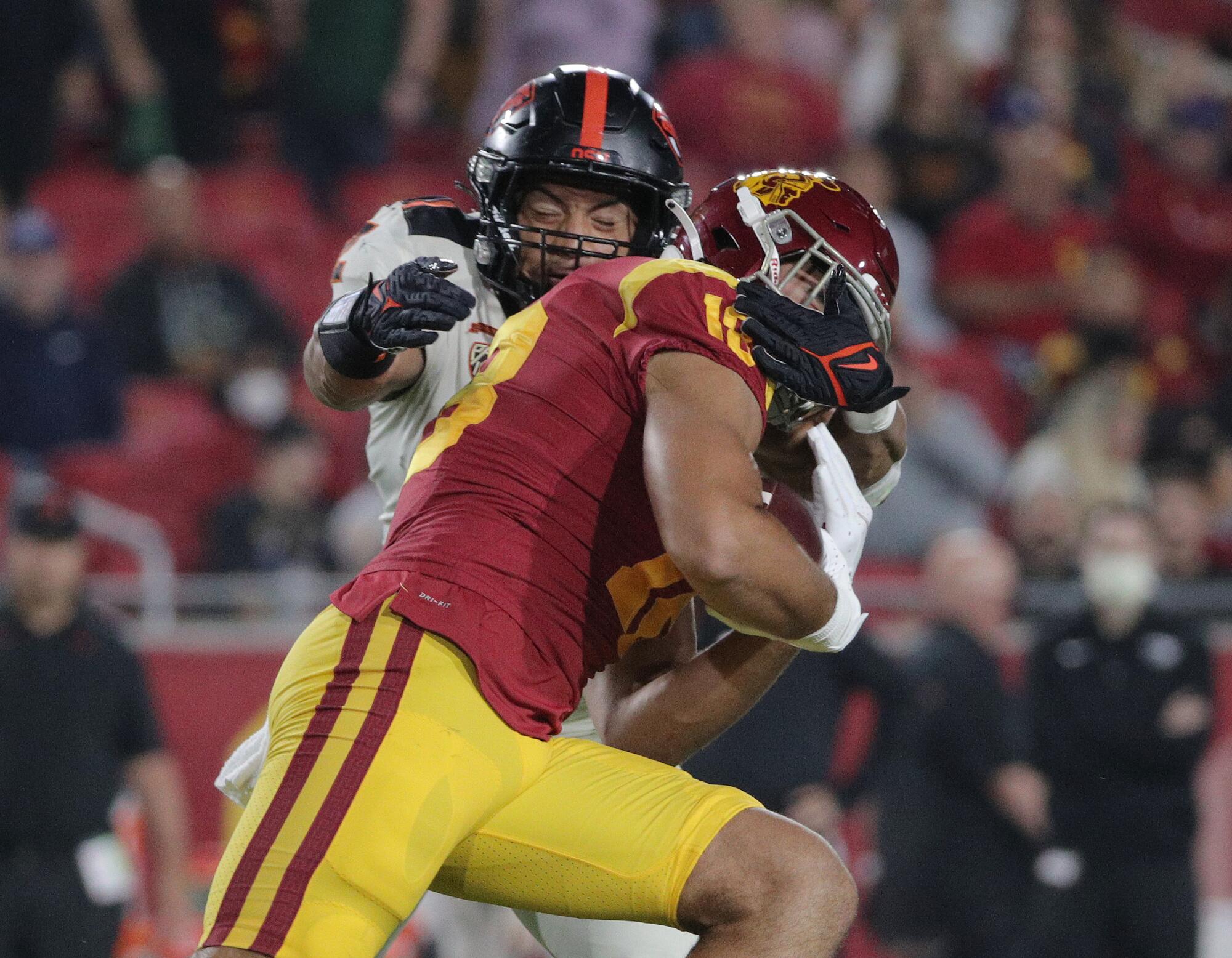 Oregon State linebacker Andrzej Hughes-Murray (2) tackles USC tight end Jude Wolfe.