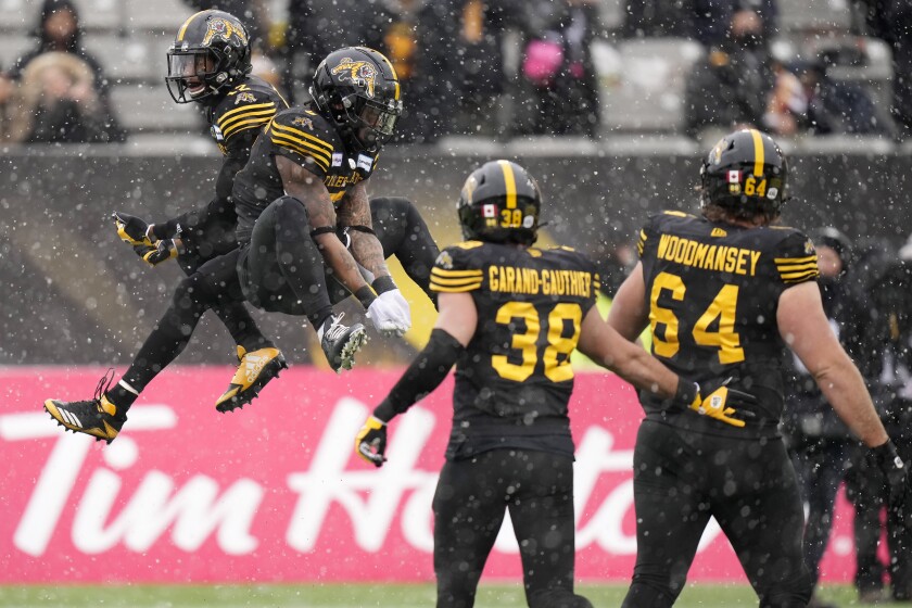Hamilton Tiger-Cats running back Don Jackson (5) celebrates his touchdown with wide receiver Tim White (12) during first half CFL division semi-final football action against the Montreal Alouettes in Hamilton, Ontario, Sunday, Nov. 28, 2021. (Nathan Denette/The Canadian Press via AP)