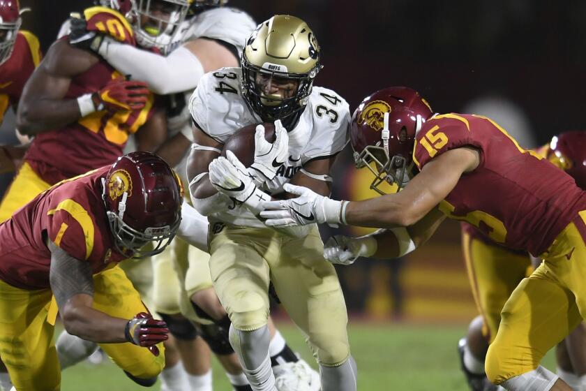 LOS ANGELES, CA - OCTOBER 13: Running back Travon McMillian #34 of the Colorado Buffaloes runs the ball into Palaie Gaoteote IV #1 and Talanoa Hufanga #15 of the USC Trojans in the second quarter at Los Angeles Memorial Coliseum on October 13, 2018 in Los Angeles, California. (Photo by John McCoy/Getty Images) ** OUTS - ELSENT, FPG, CM - OUTS * NM, PH, VA if sourced by CT, LA or MoD **