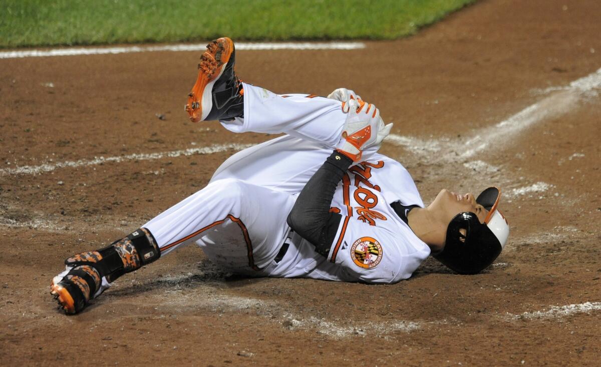 Baltimore third baseman Manny Machado holds his right knee after grounding out in the third inning of a game on Aug. 11. Machado is expected to have season-ending knee surgery.