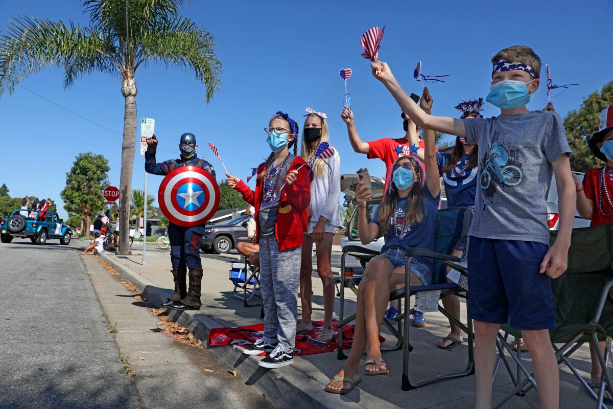 Spectators watch the OneHB Parade, a modified parade in Huntington Beach that let residents watch from their neighborhoods.