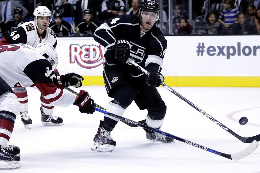 Kings defenseman Christian Ehrhoff passes the puck around Coyotes left wing Lucas Lessio during an exhibition game Sept. 22.