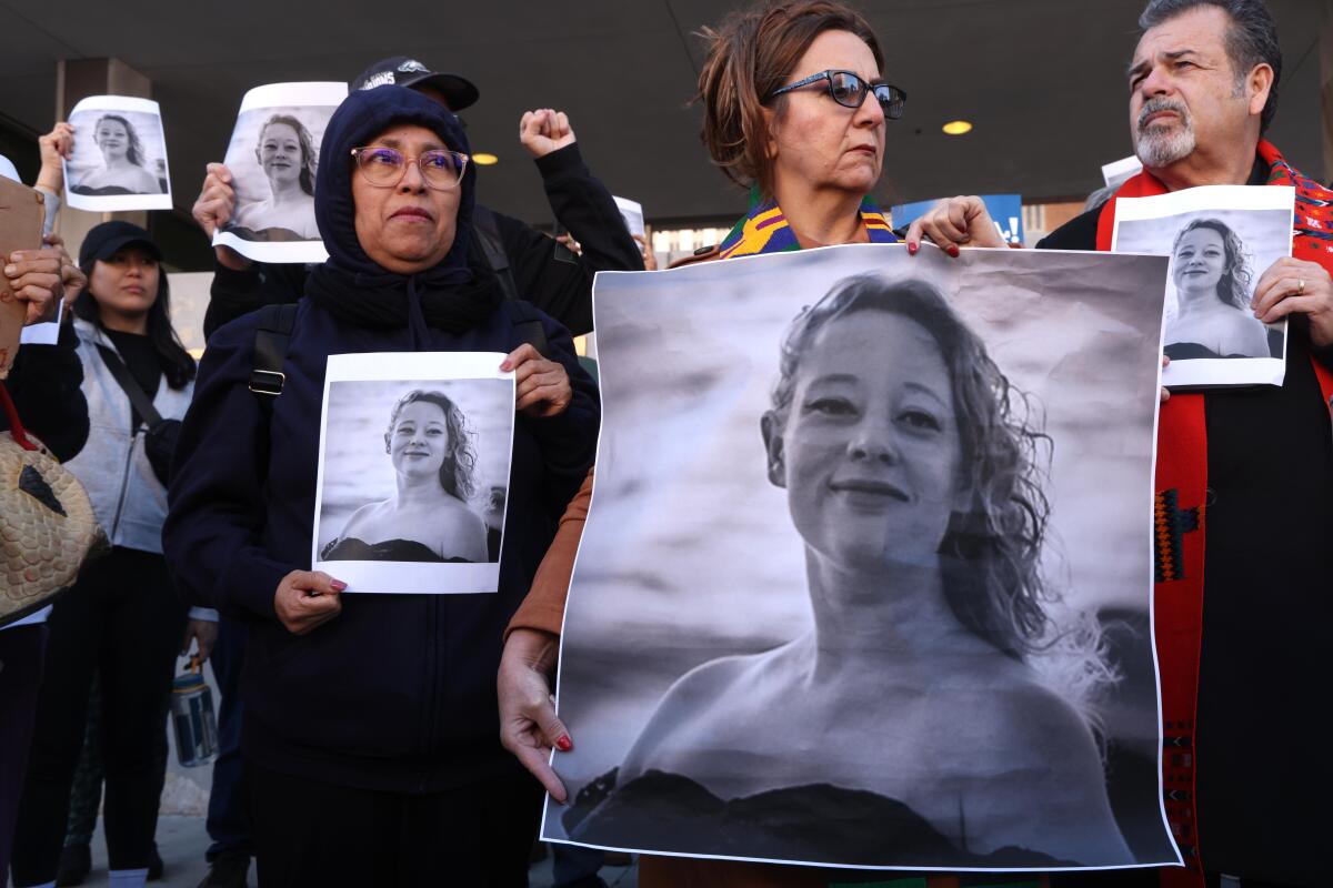 Ampara Rincon, second from right, her husband Pastor Carlos Rincon, right, hold photos of Renee Nicole Good.