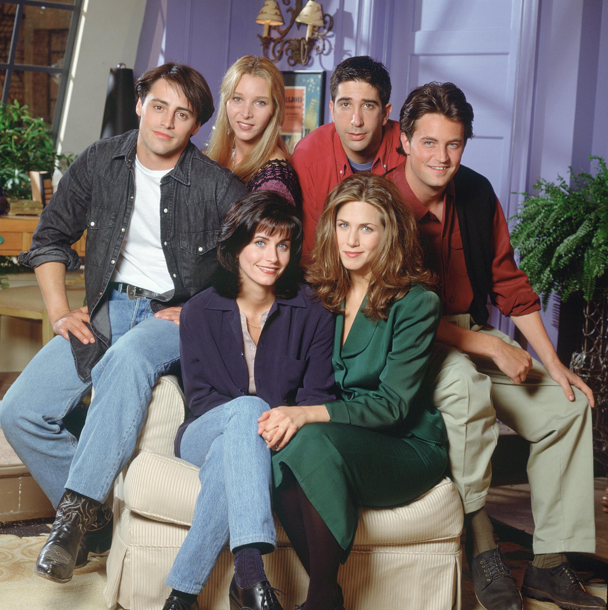 The stars of "Friends" seated in Monica's living room in Season 1.