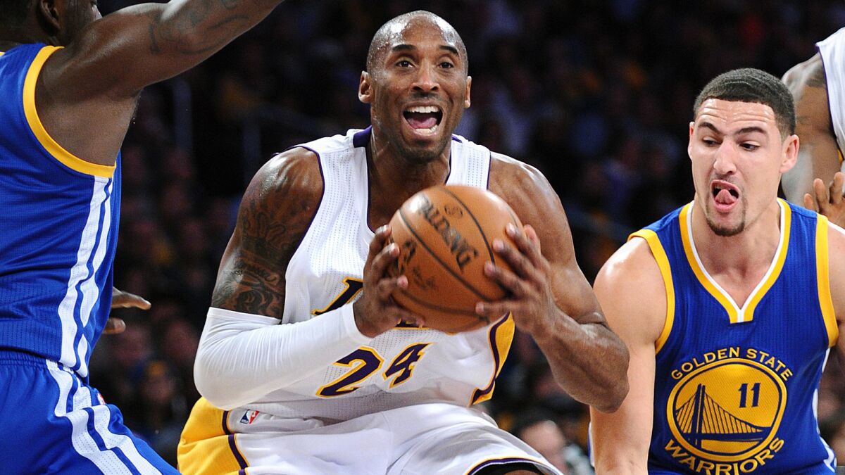 Lakers guard Kobe Bryant drives to the basket against Warriors guard Klay Thompson.