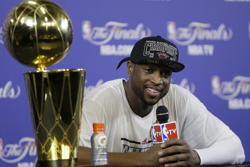 Miami Heat star Dwyane Wade, shown after the Heat won its second straight NBA title in June, has reached a settlement with his ex-wife to end their lengthy divorce battle.