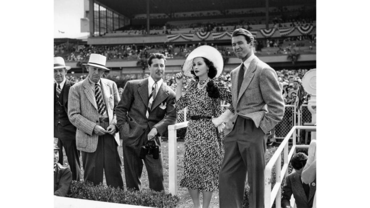 July 1940: Hollywood stars Don Ameche (holding binoculars), Hedy Lamarr and James Stewart watch the action at Hollywood Park.