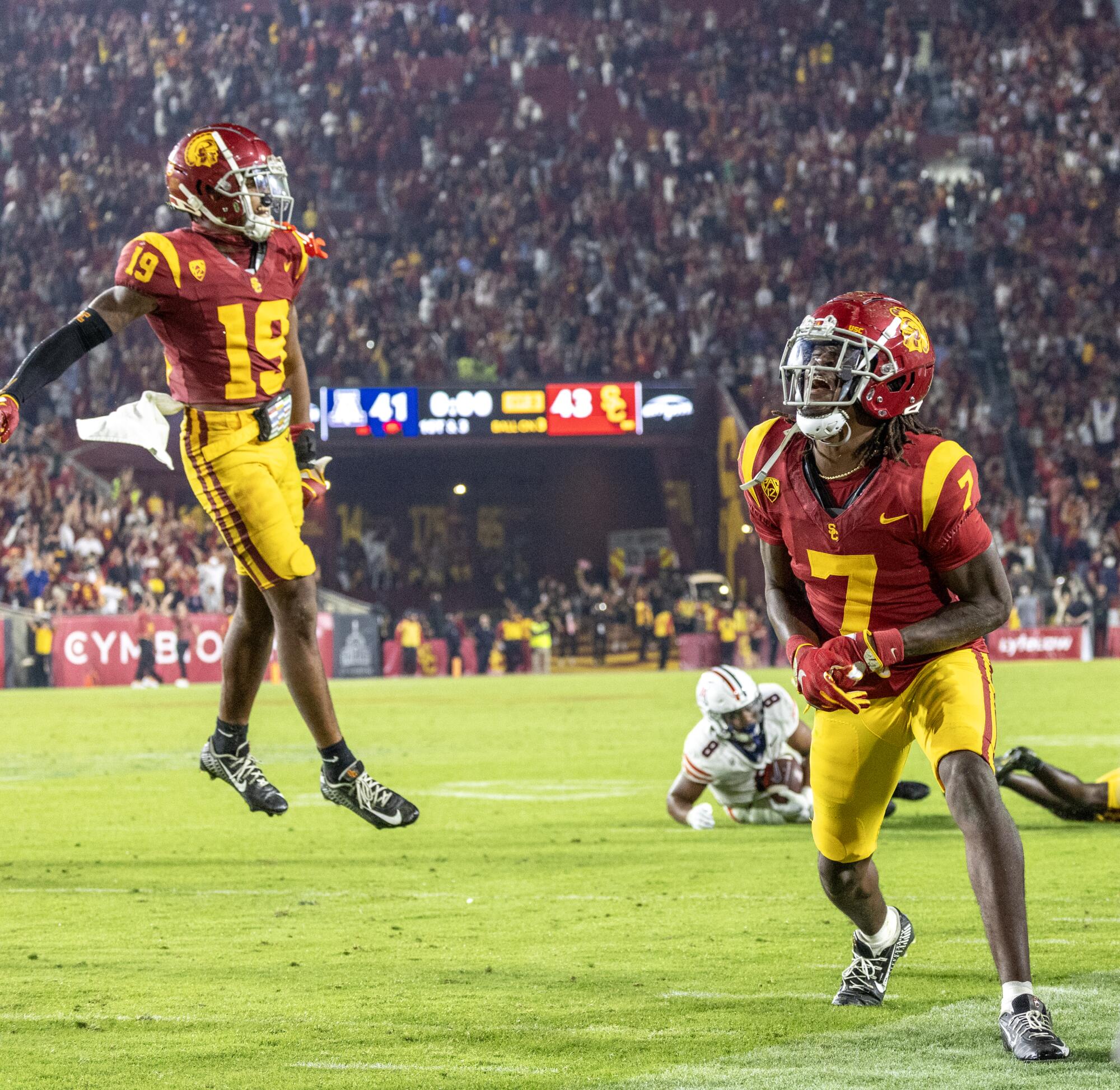USC's Calen Bullock leaps in the air as Jaylin Smith cheers.