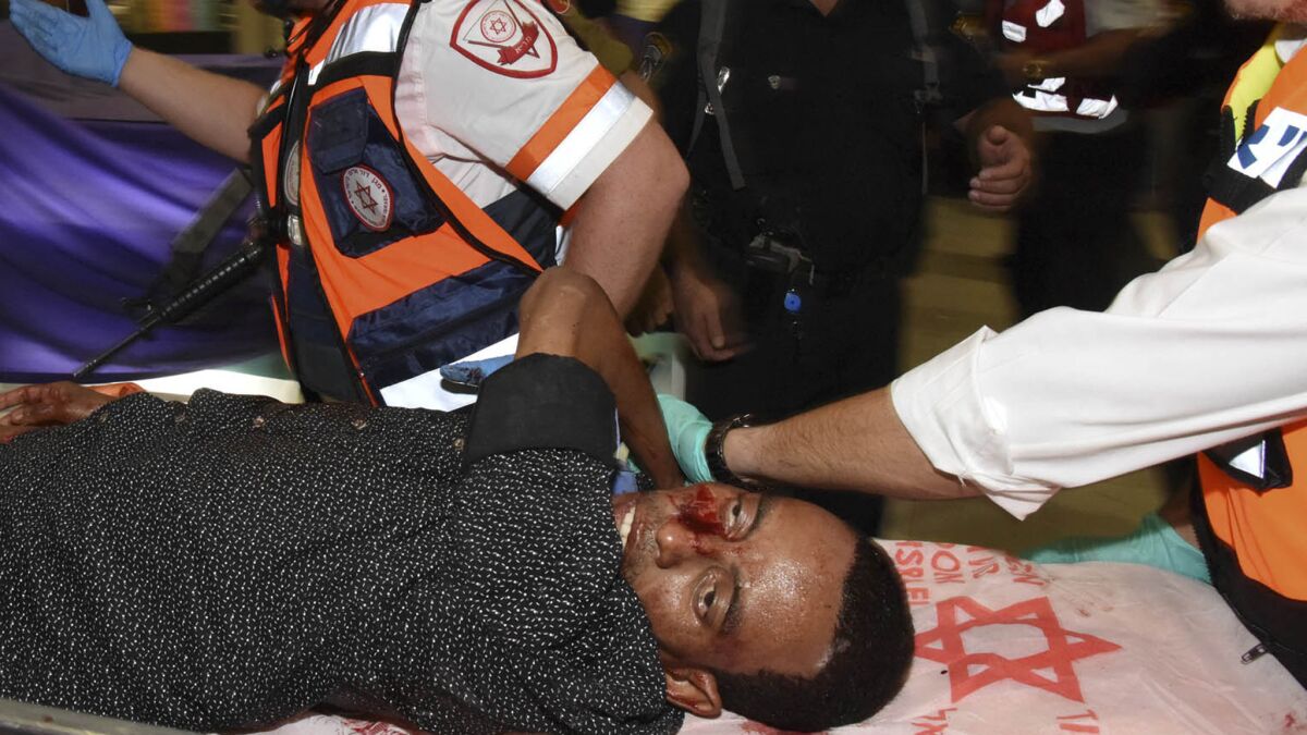 An Eritrean man mistaken for an attacker by a security guard at a bus station in Beersheba, Israel, during a shooting is evacuated after being wounded. He later died.