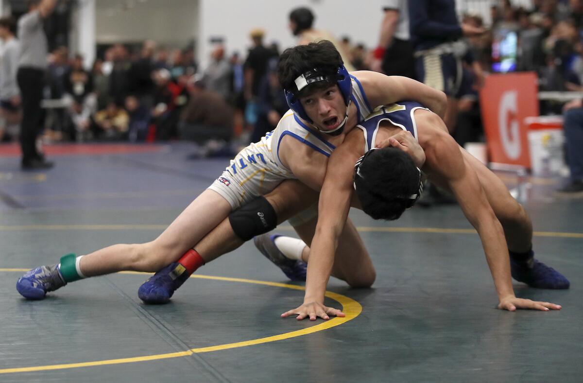 Fountain Valley's Sean Solis, top, competes for fifth place in a 113-pound medal-round match during the CIF Southern Section Masters wrestling meet at Sonora High in La Habra on Saturday.