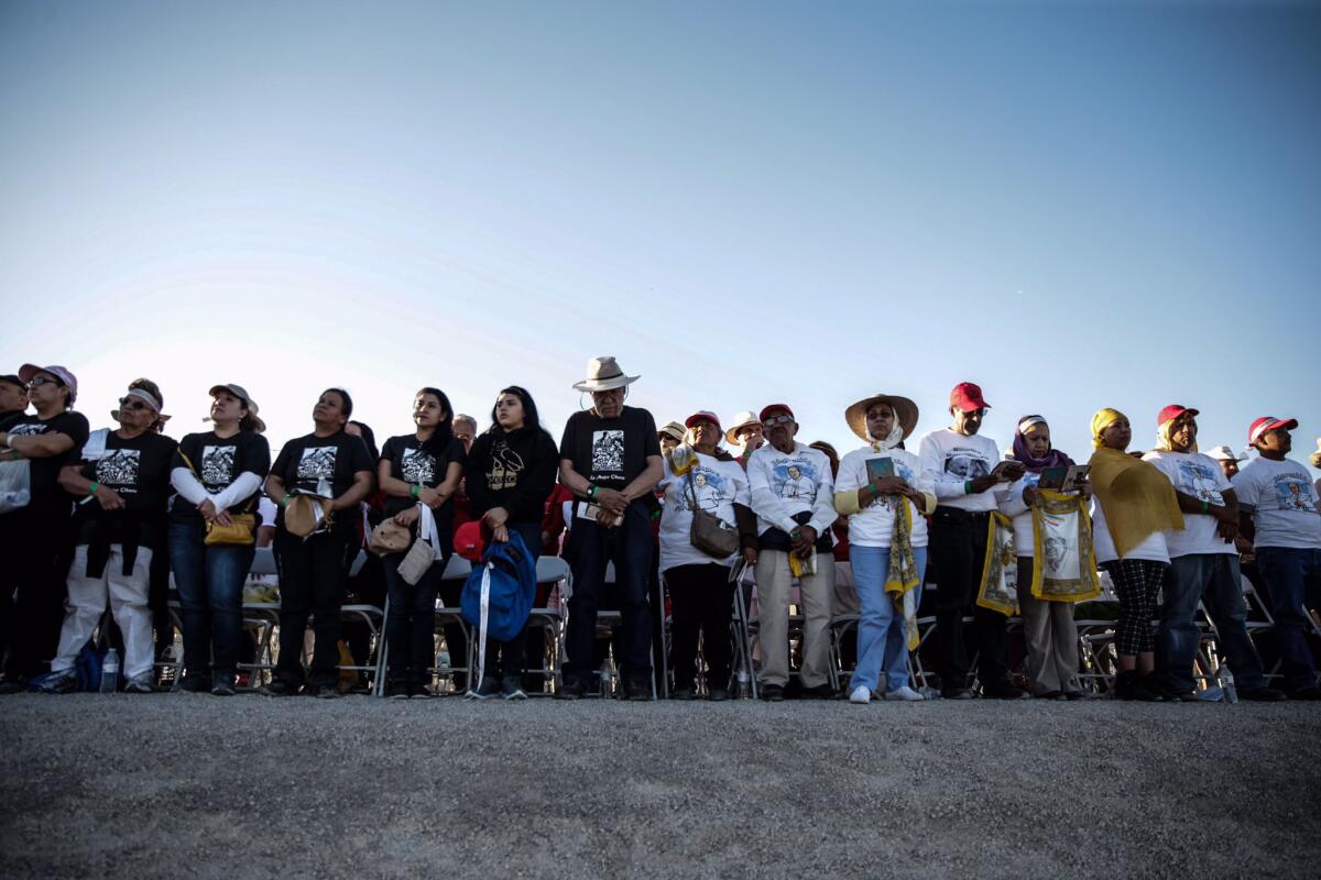 Pilgrims stand at a levee on the U.S. side of the border during the pope's Mass in Ciudad Juarez.