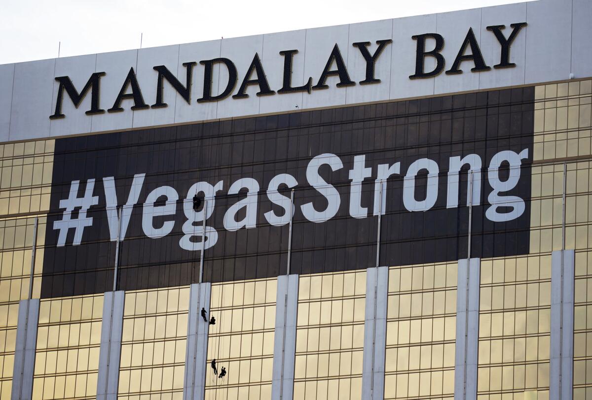 Workers install a #VegasStrong banner on the Mandalay Bay hotel