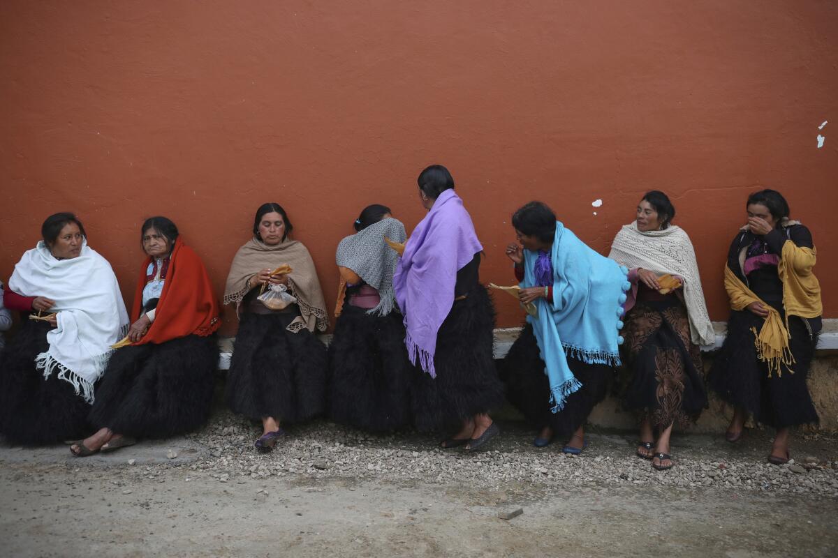 Indigenous Tzotzil women eat breakfast during a non-binding national referendum on whether Mexican ex-presidents should be tried for any illegal acts during their time in office, in the Corazon de Maria community of Chiapas state, Mexico, Sunday, Aug. 1, 2021. (AP Photo/Emilio Espejel)