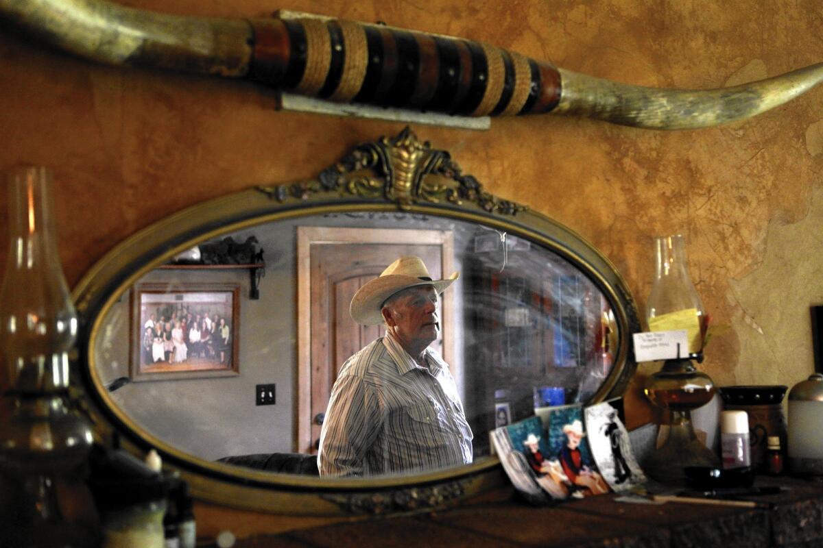 Cliven Bundy’s image is reflected in a mirror at his home in Bunkerville, Nev., in 2013.