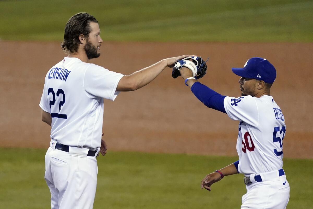 The Dodgers' Clayton Kershaw, left, high-fives Mookie Betts after a 3-0 win Oct. 1, 2020.