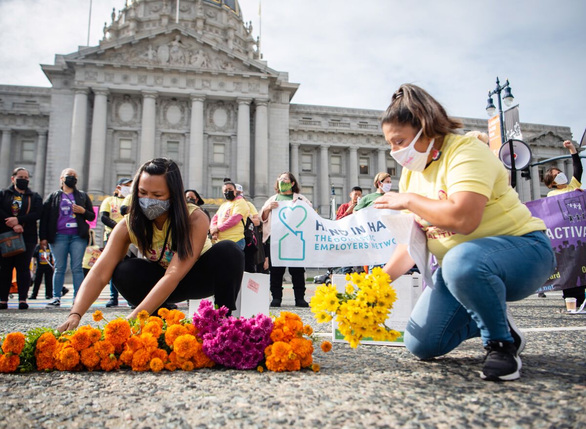 Two women lay down flowers at a demonstration