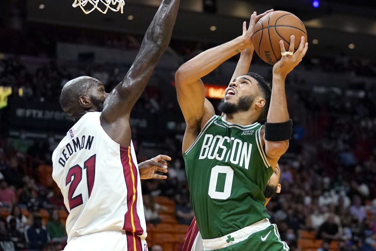 Boston Celtics forward Jayson Tatum (0) shoots as Miami Heat center Dewayne Dedmon (21) defends during the second half of a preseason NBA basketball game, Friday, Oct. 15, 2021, in Miami. (AP Photo/Lynne Sladky)