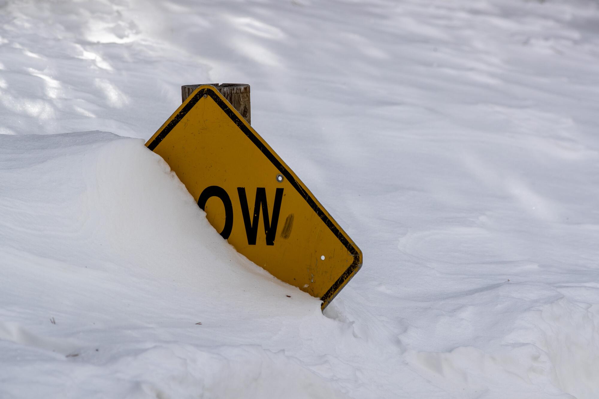 A "Slow" road sign buried in snow