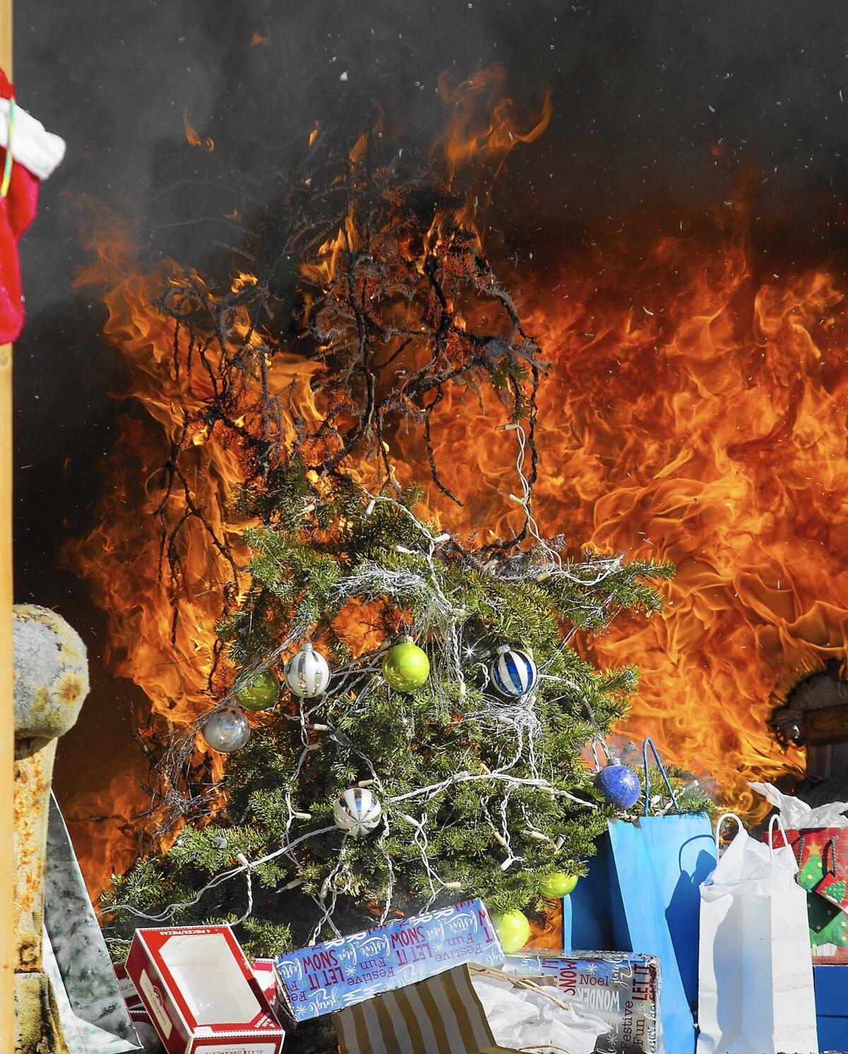A decorated Christmas tree is engulfed in flames during a fire safety demonstration Tuesday at the Orange County Fire Authority training facility in Irvine. It was part of a campaign intended to alert the public to how easily and quickly a tree can ignite and spread fire in a home.