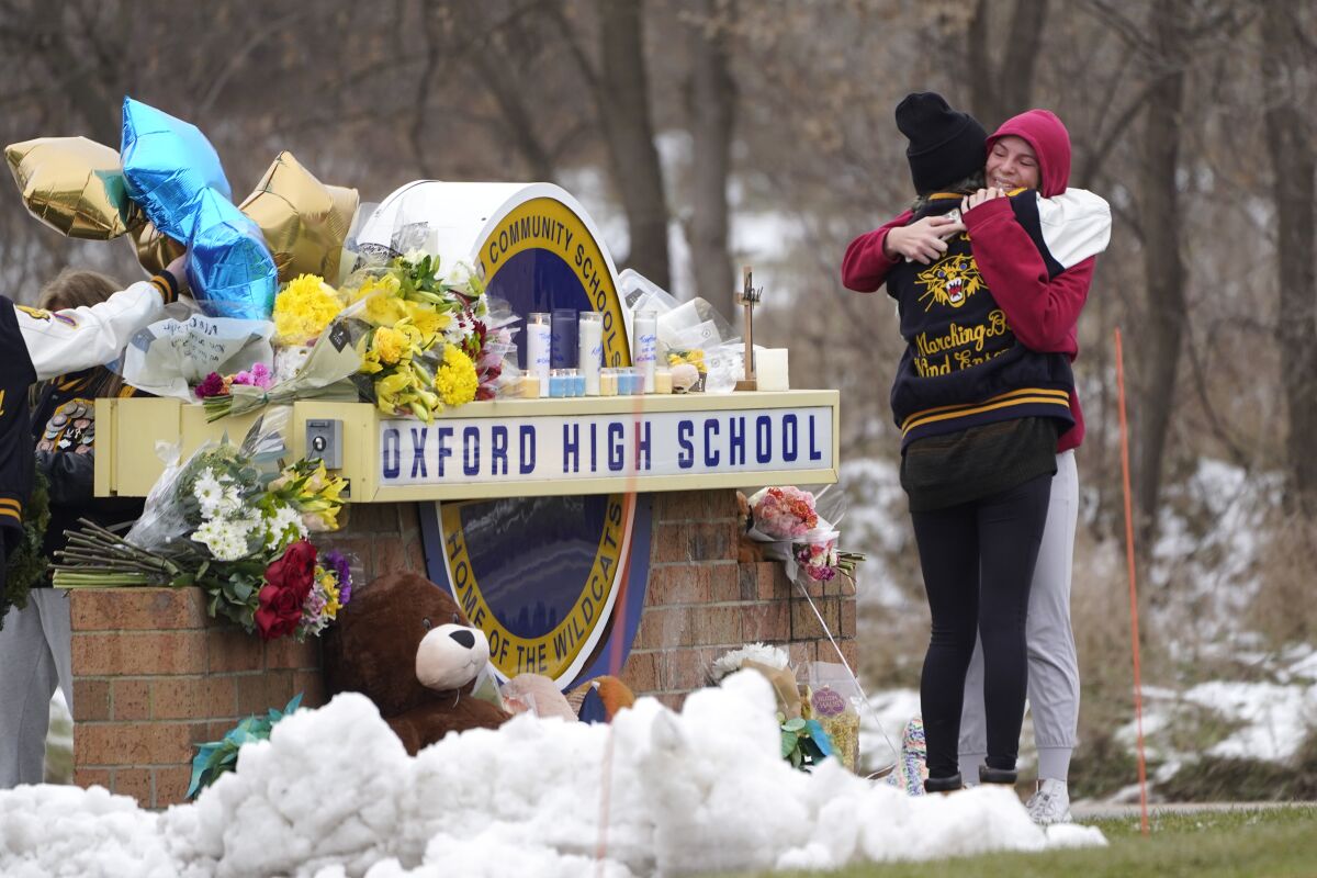 Students hug at a memorial at Oxford High School in Oxford, Mich., Wednesday, Dec. 1, 2021.
