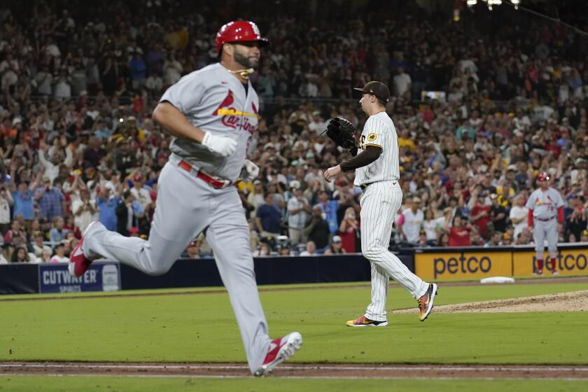 Blake Snell (derecha), de los Padres de San Diego, mira al cátcher tras ceder su primer hit, un sencillo de Albert Pujols (izquierda), de los Cardenales de San Luis, en el séptimo inning del juego de la MLB que enfrentó a ambos equipos, el 21 de septiembre de 2022, en San Diego. (AP Foto/Gregory Bull)