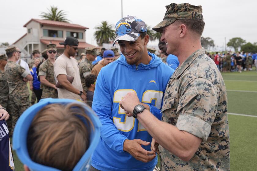 Los Angeles Chargers safety Alohi Gilman jokes with a Marine during an NFL football practice and meet and greet Tuesday, June 11, 2024, at the Marine Corps Base Camp Pendleton in Camp Pendleton, Calif. (AP Photo/Gregory Bull)
