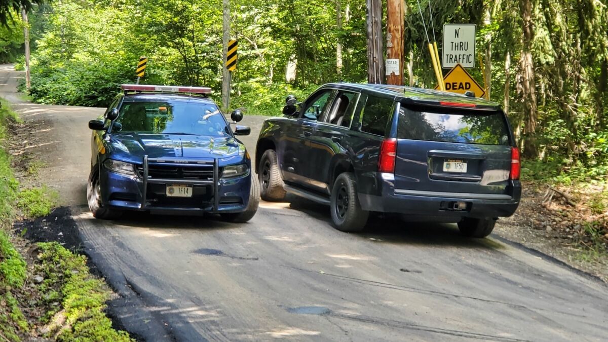 New York State Police block off a road near where the body of Roy Den Hollander was found near Livingston Manor, N.Y.