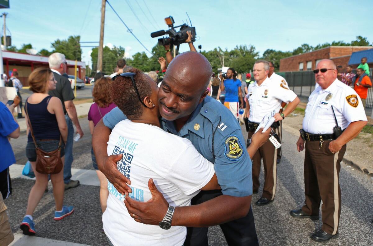 Capt. Ronald Johnson of the Missouri Highway Patrol hugs Angela Whitman on West Florissant Avenue in Ferguson, Mo., site of confrontations between protesters and police this week.