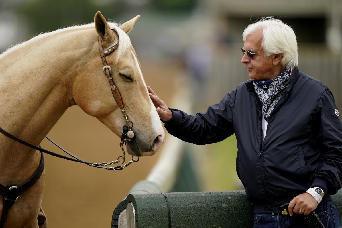 Trainer Bob Baffert pets an outrider's horse while watching workouts at Churchill Downs on Wednesday.