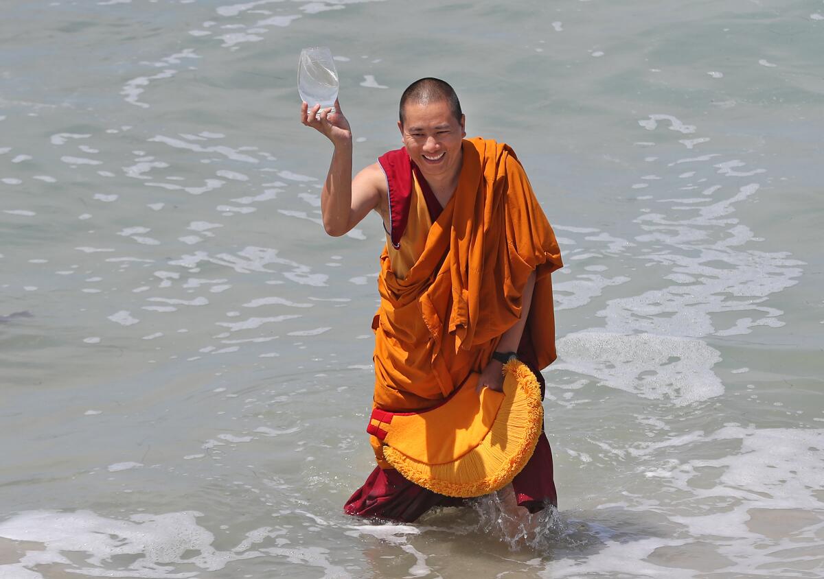 Tibetan monk Kunchok Tenzin, from the Namgyal Monastery, smiles after dropping part of the sand mandala into the ocean.