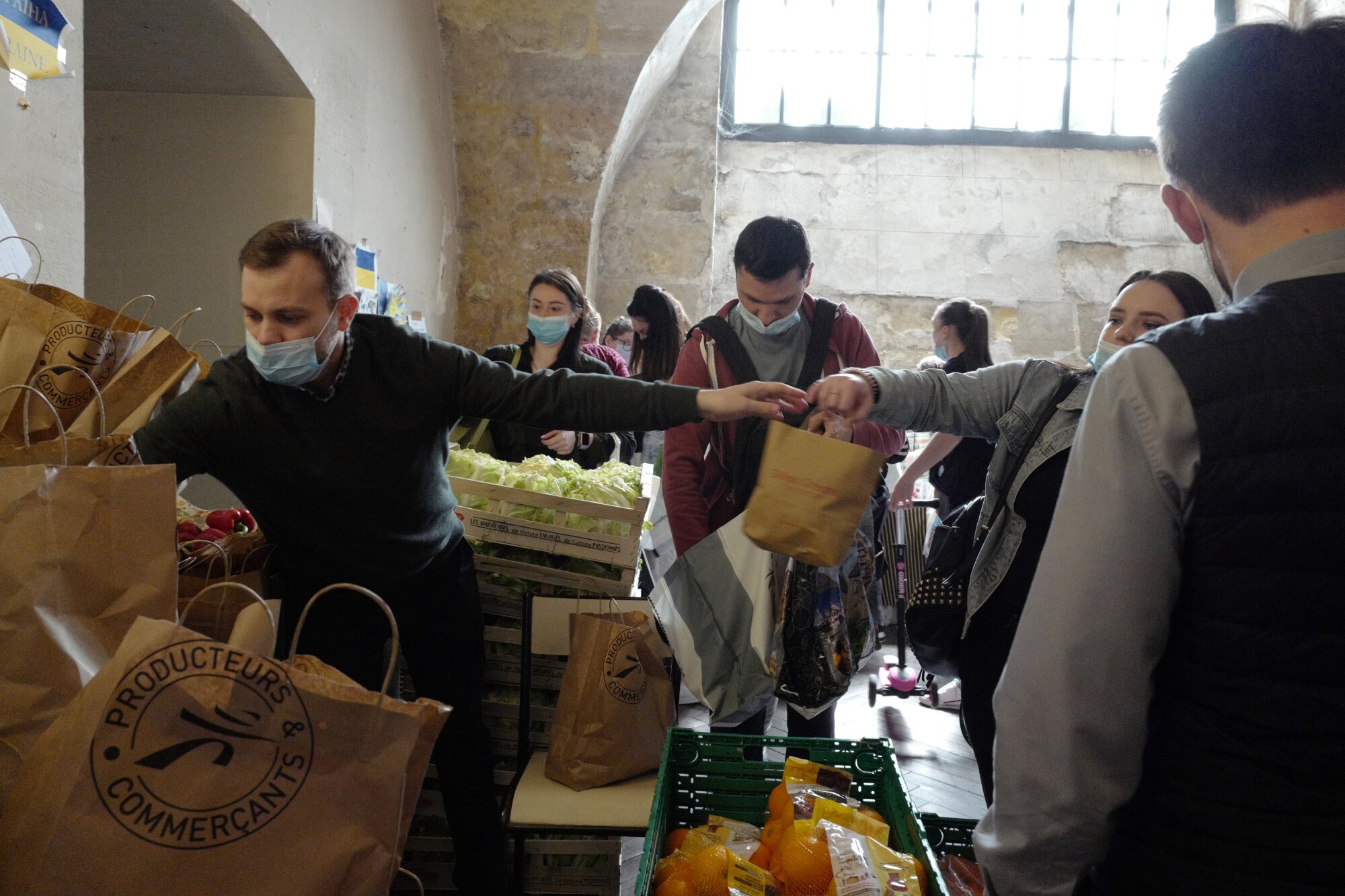 Des volontaires distribuent des sacs de nourriture et de vêtements aux réfugiés ukrainiens.