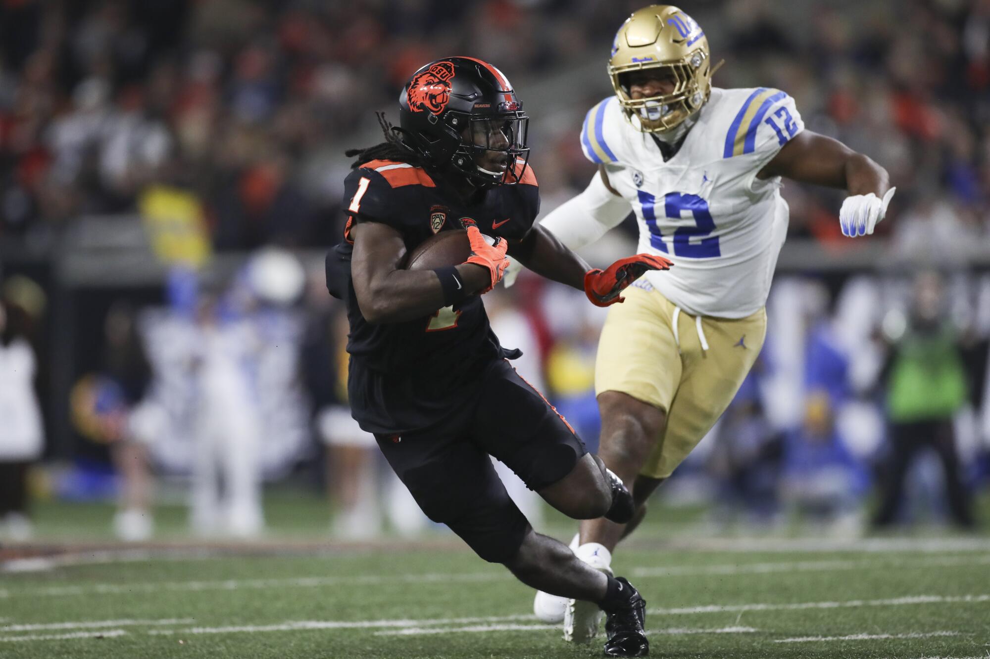 An Oregon State running back outruns a UCLA defensive lineman Saturday.