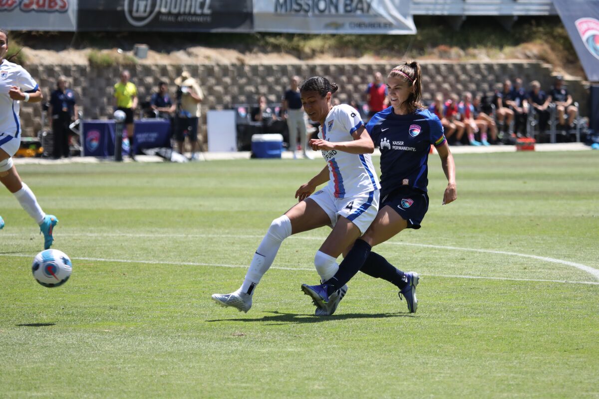 San Diego Wave forward Alex Morgan (right) scores the first goal of the match Sunday past OL Reign defender Alana Cook.