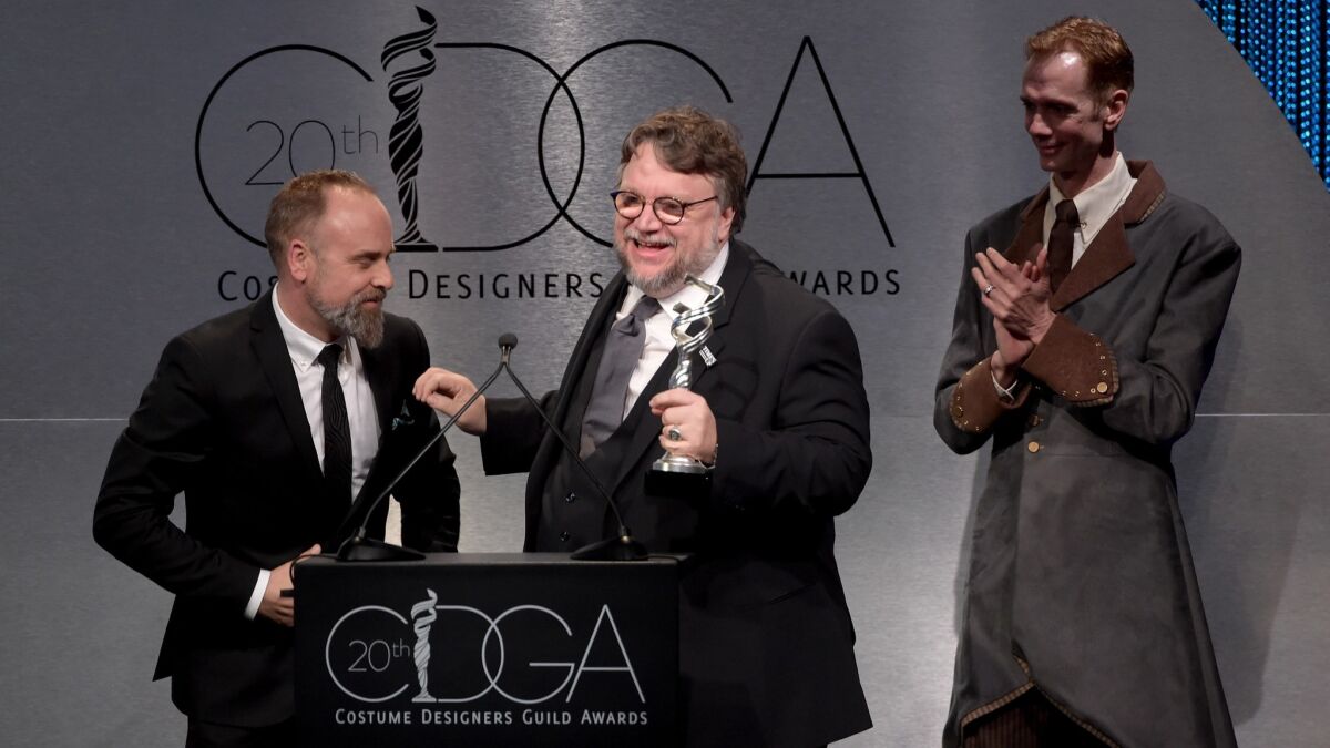 Costume designer Luis Sequeira, left, and actor Doug Jones, right, present director Guillermo del Toro with the award for distinguished collaborator at the Costume Designers Guild Awards at the Beverly Hilton Hotel on Tuesday.