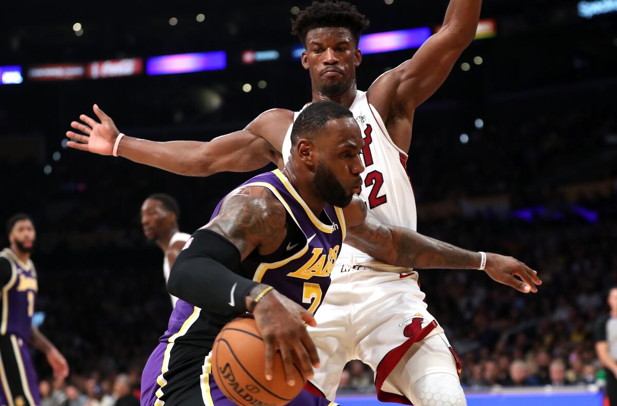 Lakers forward LeBron James tries to drive past Miami Heat forward Jimmy Butler