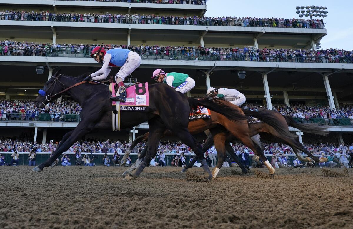 John Velazquez riding Medina Spirit leads Mandaloun and Hot Rod Charlie to win the Kentucky Derby