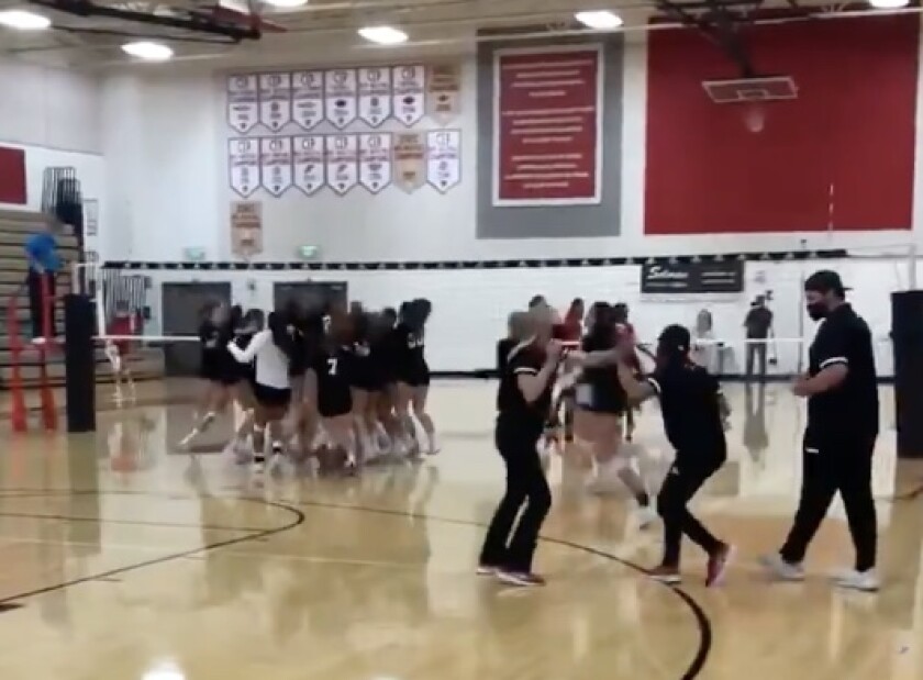 Orange Lutheran players celebrate a girls' volleyball victory over Mater Dei.