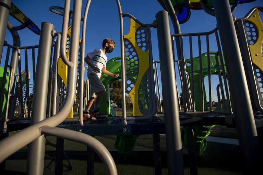 Max Tarvin, 8, the son of Gina Clayton-Tarvin, the Ocean View School District Board of Trustees President, plays on new playground equipment at College View Elementary School in Huntington Beach. The elementary school was closed for an entire school year for a complete modernization.