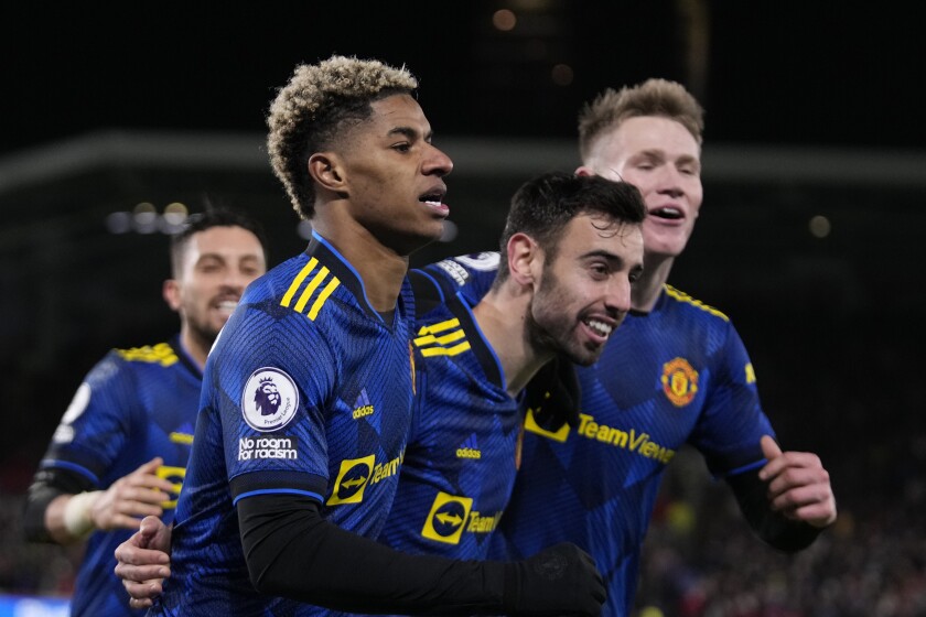Manchester United's Marcus Rashford, 2nd left celebrates with team mates after scoring his side's third goal during an English Premier League soccer match between Brentford and Manchester United at the Brentford Community Stadium in London, Wednesday, Jan. 19, 2022. (AP Photo/Matt Dunham)