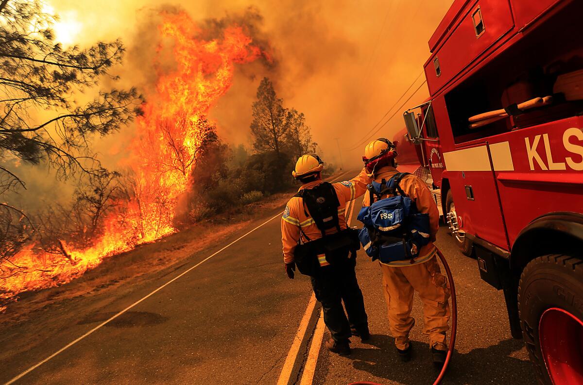 Kelseyville firefighters prepare to pull back as the Butts fire jumps Butts Canyon Road in Napa County on Tuesday.